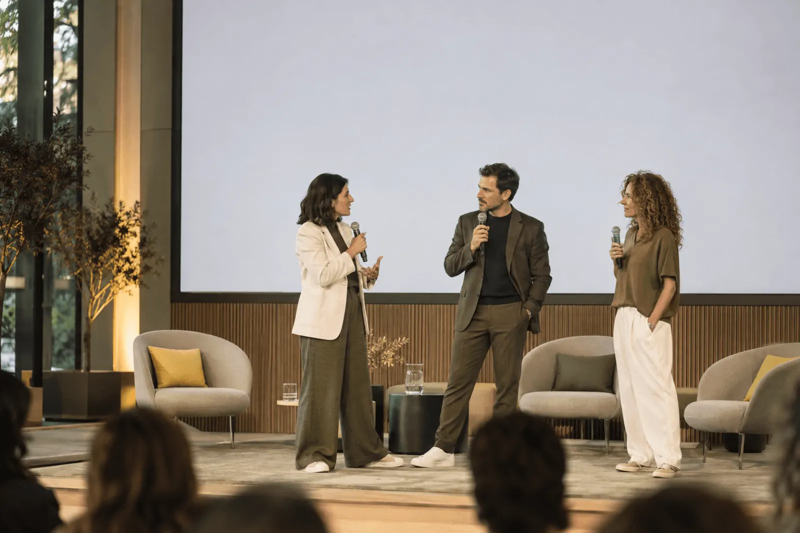 Mesa redonda con tres ponentes en un escenario
